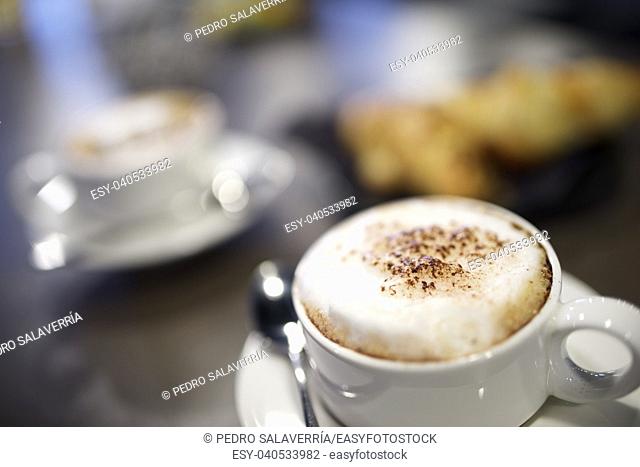 close up of cup of coffee and croissants