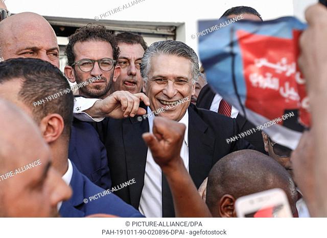 11 October 2019, Tunisia, Rades: Tunisian presidential candidate and media magnate Nabil Karoui (C) arrives for a presidential campaign rally after he was...