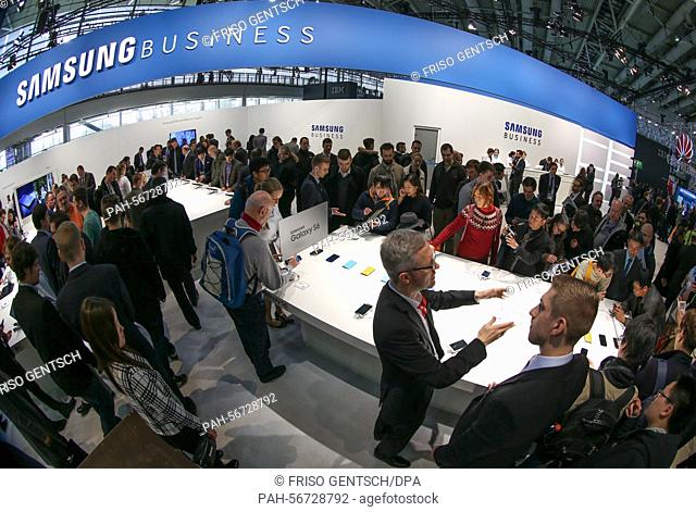Visitors look at covers for the Samsumg Galaxy S6 smartphone at the Samsung exhibition booth on the opening day of the CeBIT 2015 international computer expo in...