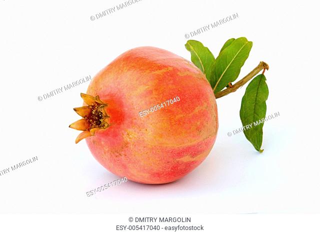 Ripe pomegranates on green leaves isolated on white background