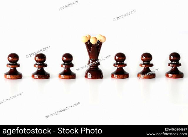Row of black pawn chess pieces with queen in the middle on white background - stand out of the crowd concept