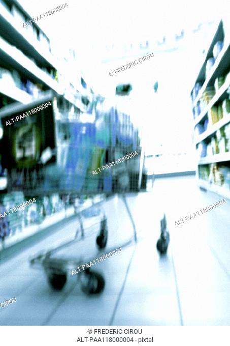 Shopping cart in supermarket, blurred