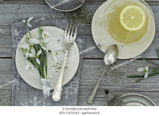 A place setting with snowdrops and a cup of bergamot tea