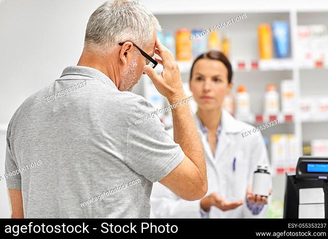 pharmacist and old man with medicine at pharmacy