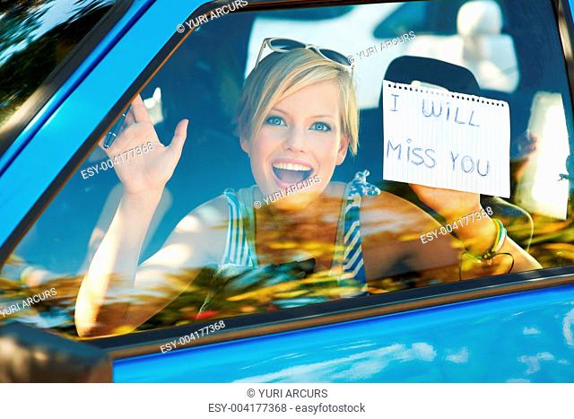 Portrait of woman in car with a note that says 'I will miss you'