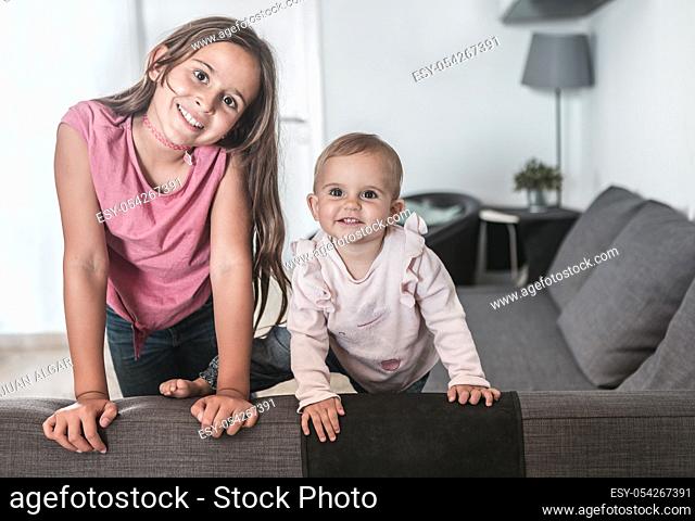 Two girls smiling on the couch at home