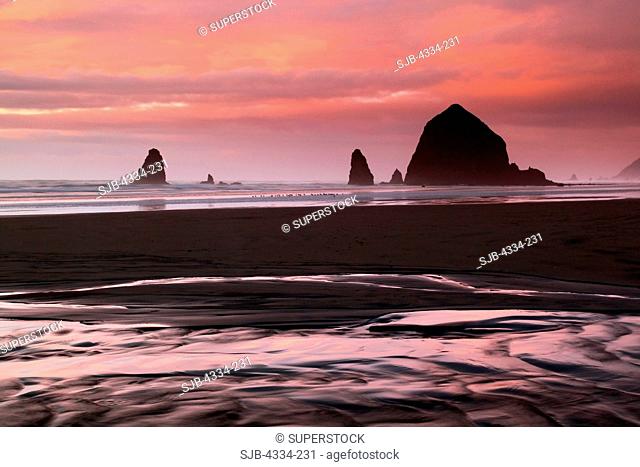 Sunset along Cannon Beach, Oregon. The Haystack right and the Needles are out in the surf