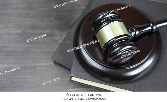 Wood gavel and on the old book on a dark wooden background, top view