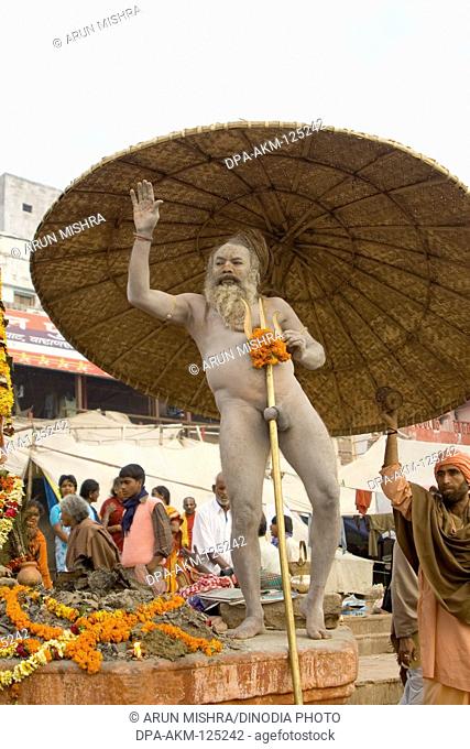Hindu saint naga baba Shivdasgiri warping penis with trishul rod in Varanasi on Ganga river ; Uttar Pradesh ; India MR707A