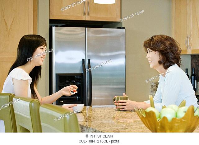 Mother and daughter talking in kitchen