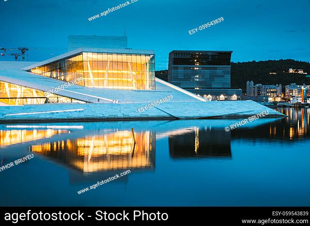 Oslo, Norway. Scenic Night Evening View Of Illuminated Norwegian National Opera And Ballet House Among Contemporary Buildings