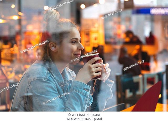 Young woman in a cafe drinking and enjoying a coffee