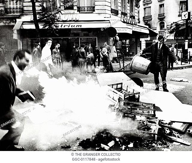 PARIS STUDENT REVOLT, 1968.Students feeding the fire set to a barricade of garbage at Boulevard St. Germain on the Left Bank in Paris, France, 23 May 1968