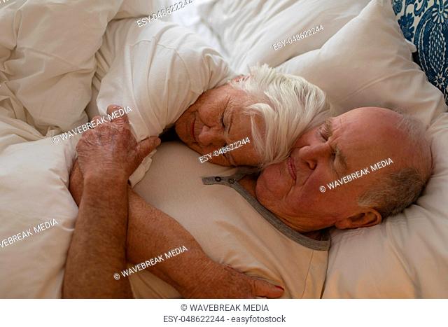 Senior couple sleeping together in bedroom