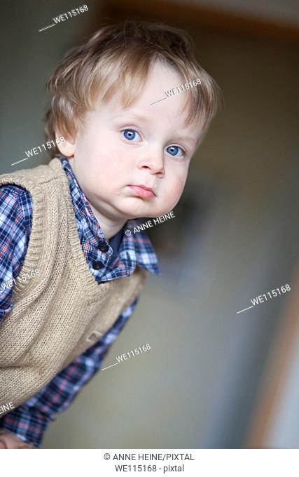portrait of 1 year old boy looking into distance, thoughtful