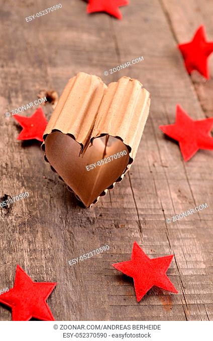 Love concept background with a heart shaped piece of cardboard on a rustic wooden table