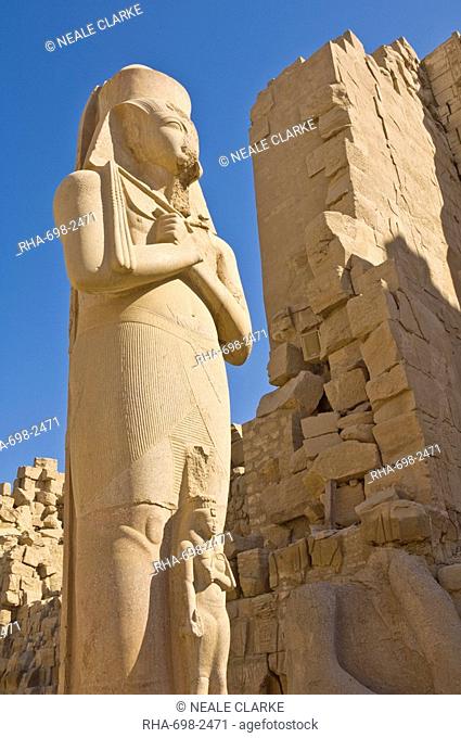 Giant statue of the great pharaoh Rameses II with the small statue of his daughter Bent'anta between his legs in the forecourt behind the first Pylon of the...