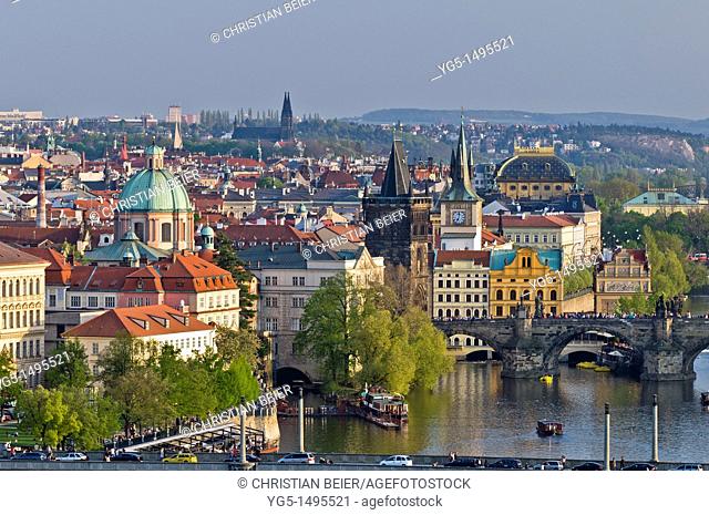 View along the Vltava River in Pragues Old Town in the evening with Church of St Francis, Old Town Bridge Tower, Charles Bridge, National Theatre, Prague