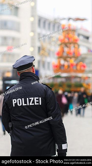01 December 2023, Lower Saxony, Hanover: A police officer walks through the city center. The investigation into a 20-year-old arrested in Lower Saxony for...