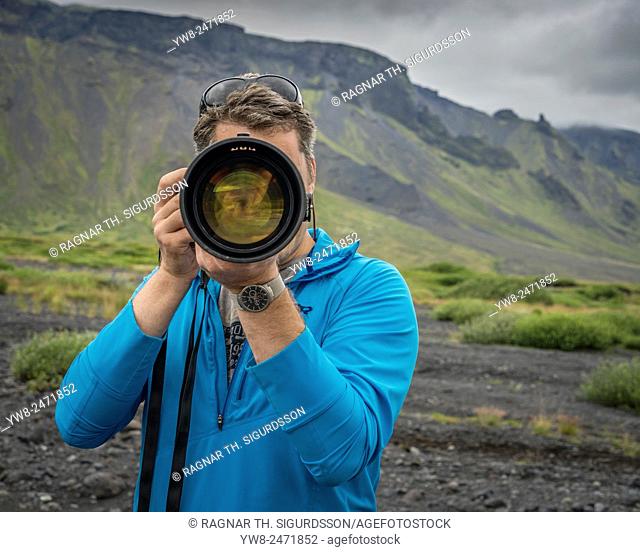 Photographer with long lens shooting by Seljalandsfoss Waterfall, Iceland