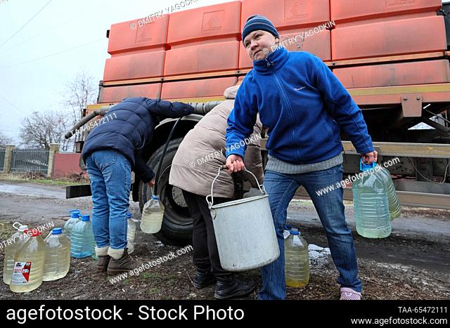 RUSSIA, DONETSK - DECEMBER 4, 2023: People fill bottles with water from a tank truck in Donetsk's Leninsky District. Due to problems with water supply