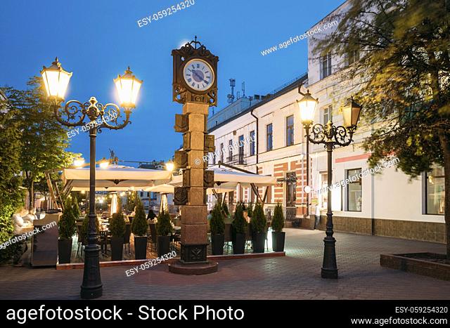 Brest, Belarus. Two-Sided Clock In Old-Fashioned Decoration With Arms Of City Of Different Times In Form Of Six-Meter Bronze Monument On Pedestrian Sovietskaya...