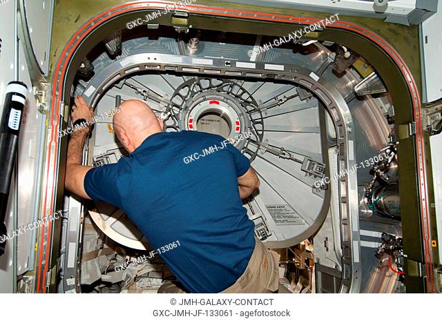 European Space Agency astronaut Luca Parmitano, Expedition 36 flight engineer, closes the hatch in the vestibule between the International Space Station's...