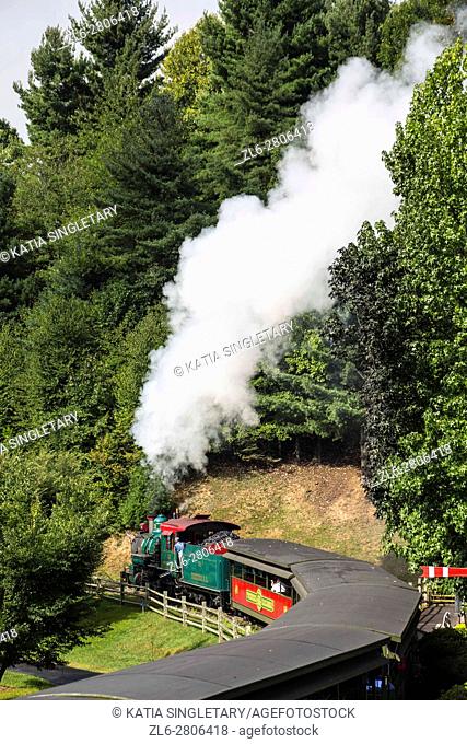 Photo of the dark toxic steam coming out of an old fashion steam locomotive train full of coal is driving through the mountains of North Carolina at tweets...