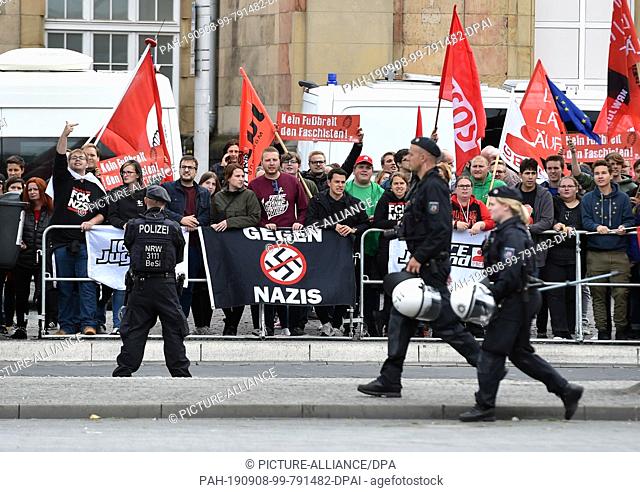 08 September 2019, North Rhine-Westphalia, Mönchengladbach: Demonstrators against the march of right-wing groups hold up flags and signs with the inscriptions...