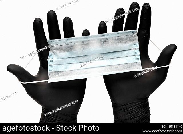 Medical man holds antivirus face mask in hands in black medical gloves. Isolated on white background. Pandemic insurance, airborne diseases, SARS, grippe