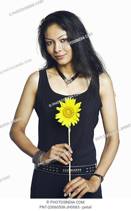 Portrait of a mid adult woman holding a sunflower