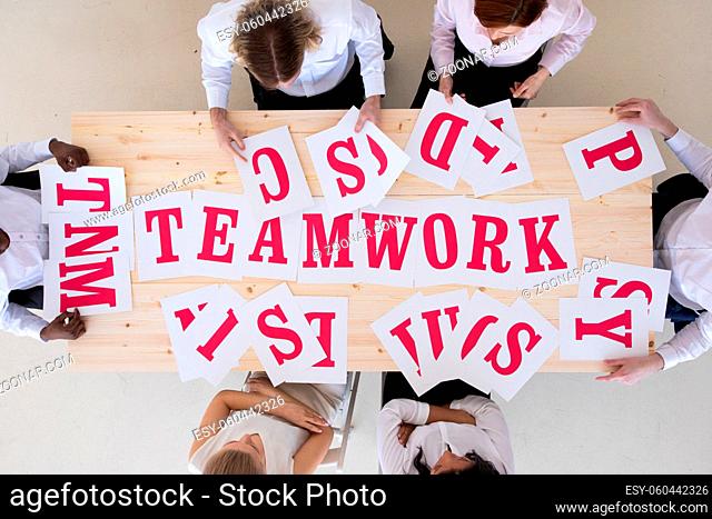 Multi-ethnic group of diverse people putting letters together teamwork cooperation concept