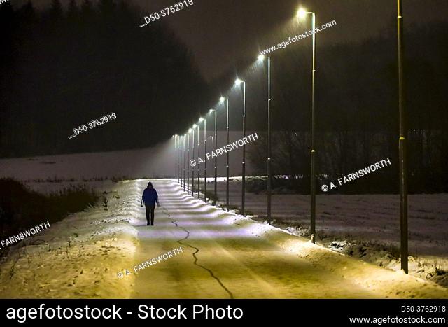 Stockholm, Sweden A man walks on a snowy illuminated path in the suburb of Huddinge