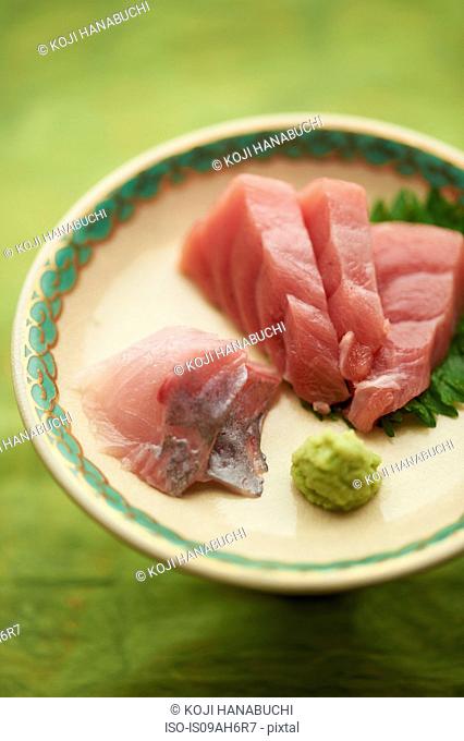 Still life of raw sliced fish dish with leaves