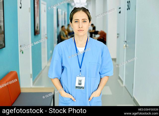 Nurse wearing scrubs standing in hospital corridor