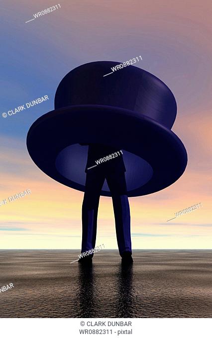 Low angle view of a businessman standing in an oversized top hat