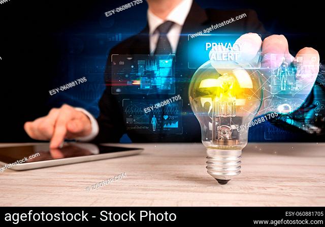Businessman holding lightbulb with PRIVACY ALERT inscription, online security idea concept