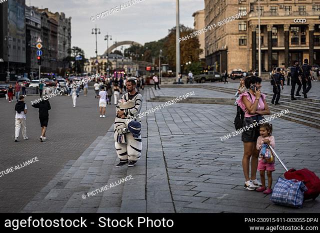 13 September 2023, Ukraine, Kiev: A picture taken on 13 September shows a Ukrainian man earning money by posing in a zebra costume at Independence Square