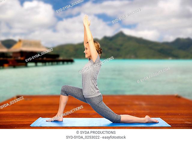 happy woman making yoga in low lunge outdoors