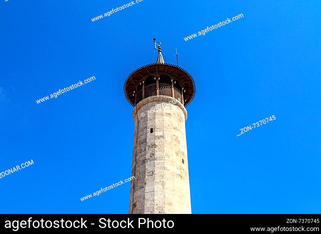 Bottom view of historical old stone minaret of Habibi Neccar Mosque in Antakya, on blue sky background