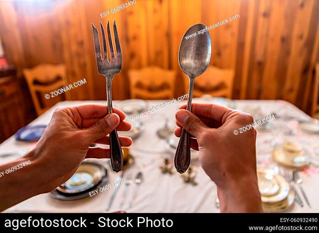Hands holding fork and spoon, getting prepared to start eating. Discover historical kitchen relics in Kootenays, British Columbia, Canada
