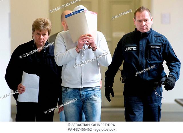 A man accused of sexual assault and grievous bodily harm (L) arrives to hear the verdict at the regional court in Braunschweig, Germany, 21 February 2013