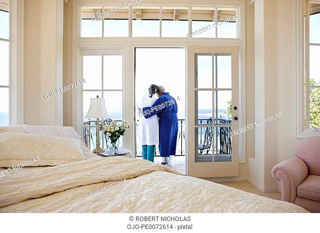 Senior couple hugging on balcony