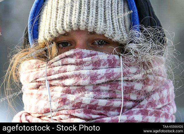 RUSSIA, OMSK - DECEMBER 8, 2023: A girl wrapped in a woolen scraf walks in the Siberian city of Omsk on a frosty winter day