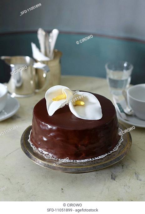 An almond and chocolate cake decorated with calla lilies