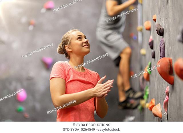 man and woman climbing a wall at indoor gym