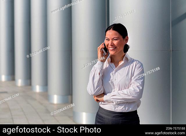 Attractive young asian businesswoman talking over mobile phone