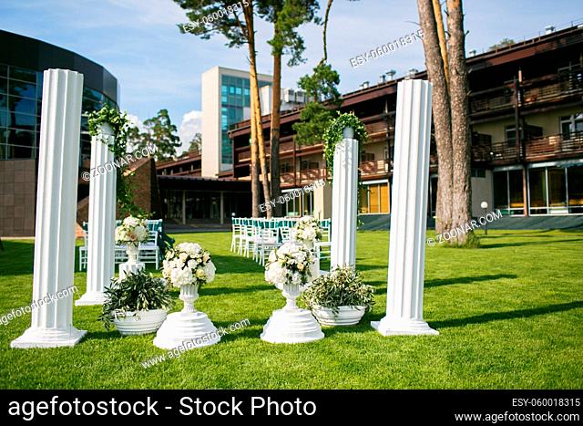White wedding chairs with green ribbon outdoors