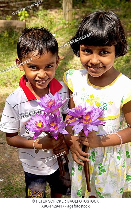children offering flowers for buddha at the Devinuwara Devalaya Temple in Dondra, southern Sri Lanka