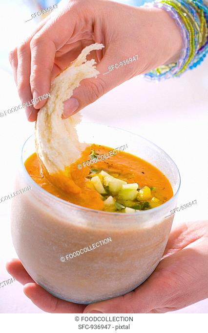 Dipping bread into gazpacho